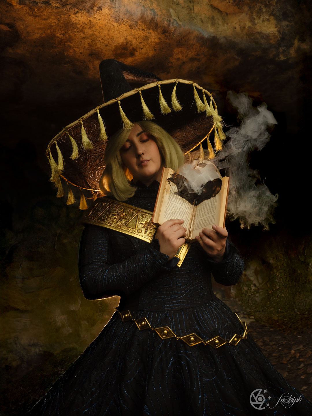 Milou steht vor einem gold-schwarzen Hintergrund in ihrem Coco Kostüm, das Kleid ist schwarz mit goldenen Akzenten und hält ein Buch in der Hand.