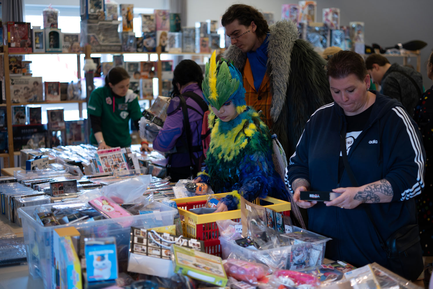 Man sieht Besuchende, die die vollen Tische des Bring & Buy durchstöbern.